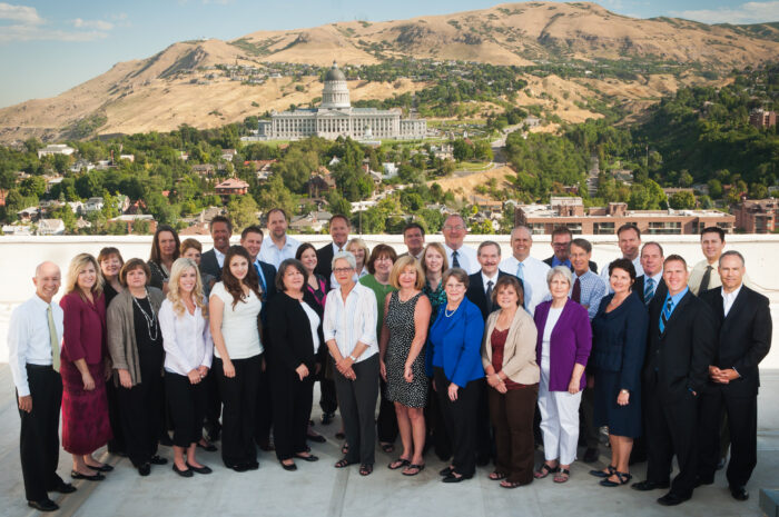 A large group of Diversified Insurance group employees stand in front of the Utah state capitol