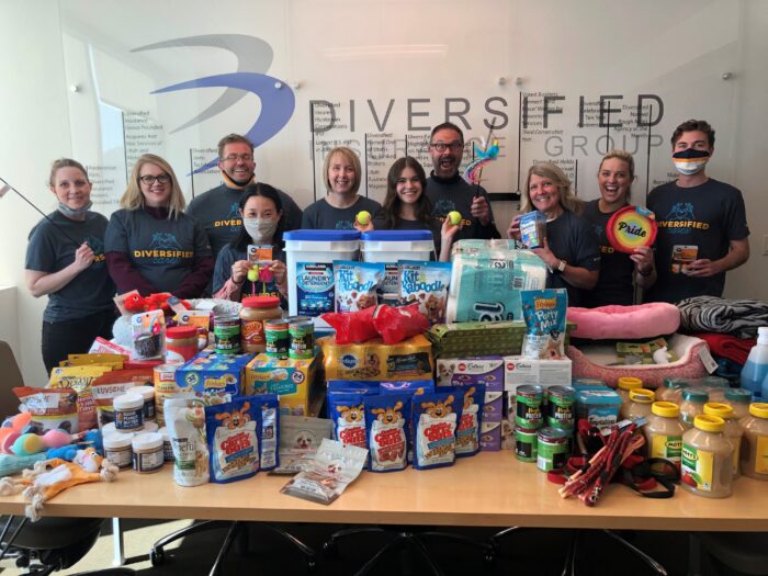 employees holding donations for diversified insurance group 20th anniversary initiative
